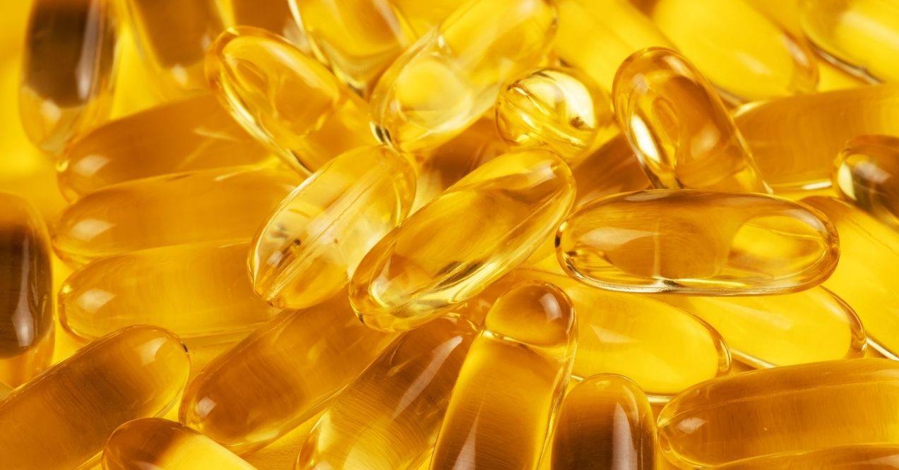 Fish oil capsules on a yellow background